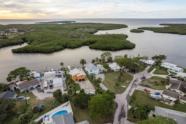 aerial view at dusk featuring a water view