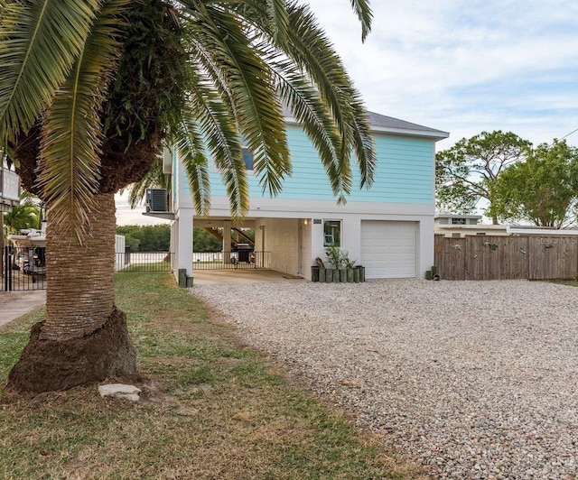 view of side of home featuring central AC unit and a garage