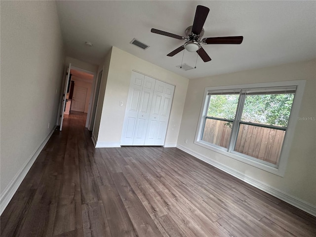 unfurnished bedroom with dark hardwood / wood-style flooring, ceiling fan, and a closet