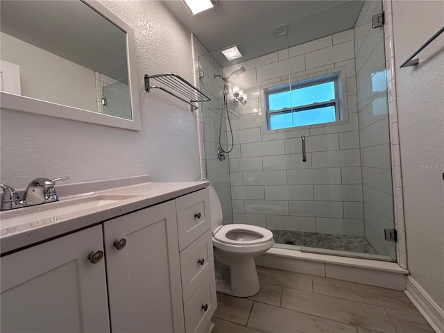 bathroom featuring vanity, toilet, tile patterned floors, and walk in shower