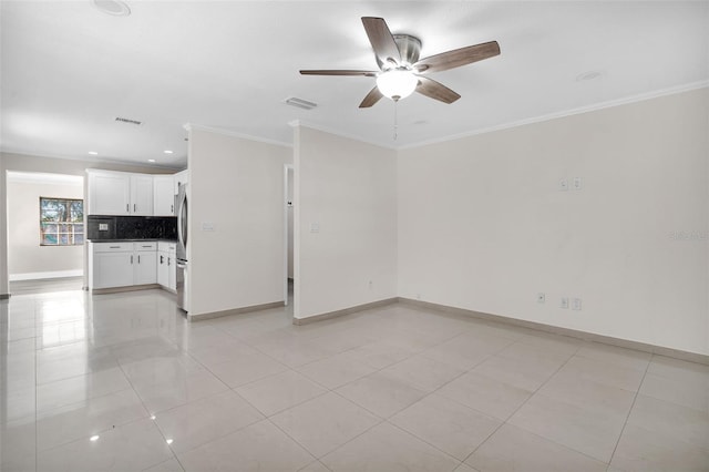 spare room featuring ceiling fan, ornamental molding, and light tile patterned floors