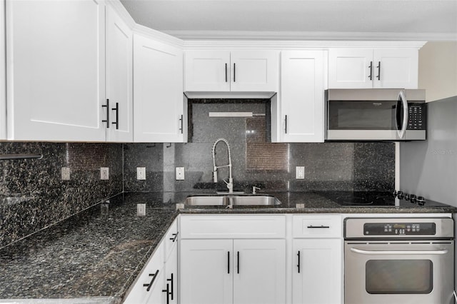 kitchen featuring stainless steel appliances, sink, white cabinets, and backsplash