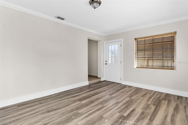 spare room with crown molding and wood-type flooring