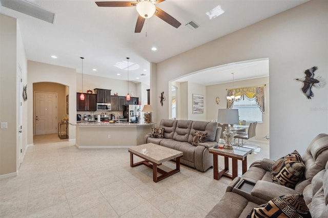 living room featuring ceiling fan with notable chandelier