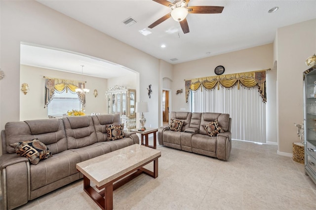 living room with ceiling fan with notable chandelier