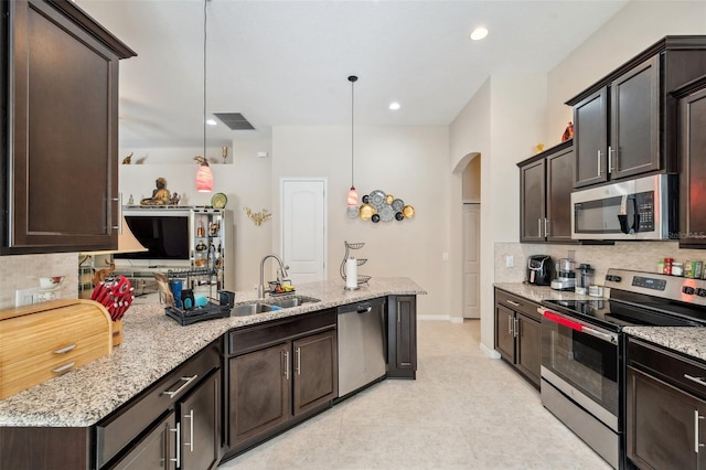 kitchen with sink, pendant lighting, dark brown cabinetry, and appliances with stainless steel finishes