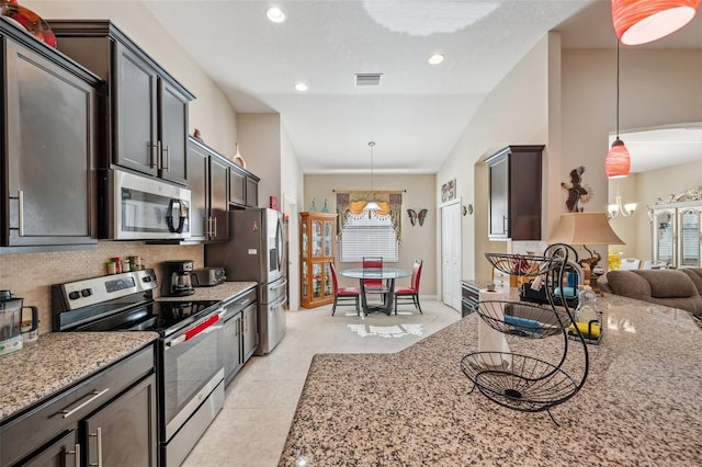 kitchen with stainless steel appliances, hanging light fixtures, tasteful backsplash, and lofted ceiling