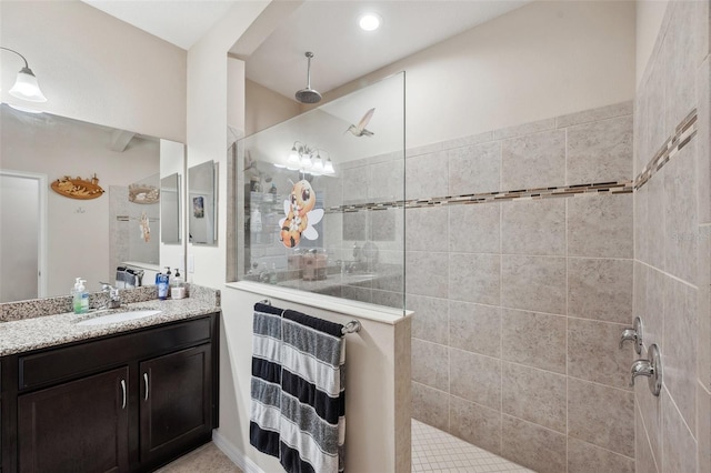 bathroom featuring a tile shower and vanity