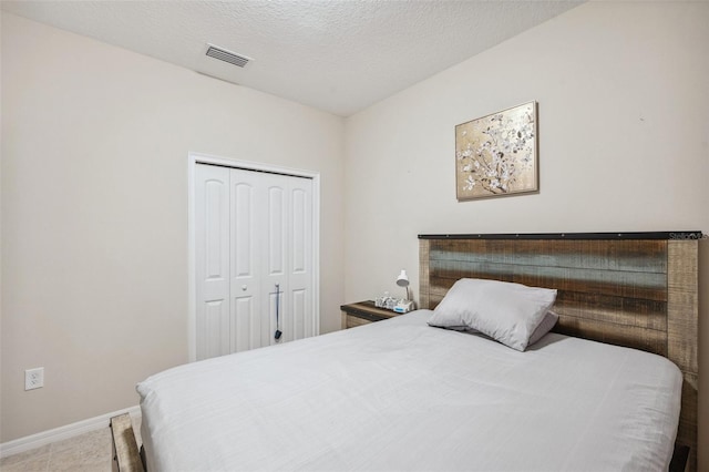 bedroom with a textured ceiling and a closet