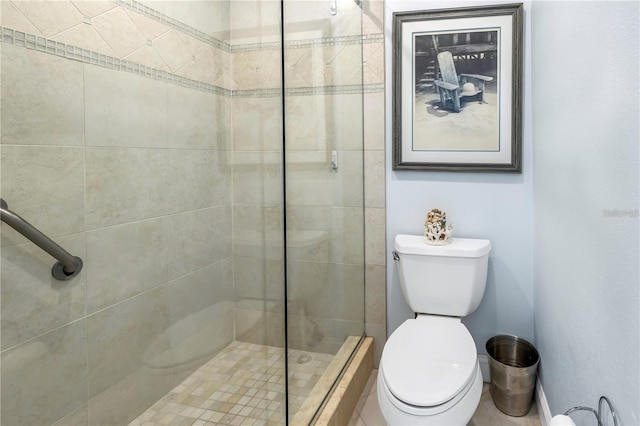 bathroom with a tile shower and toilet