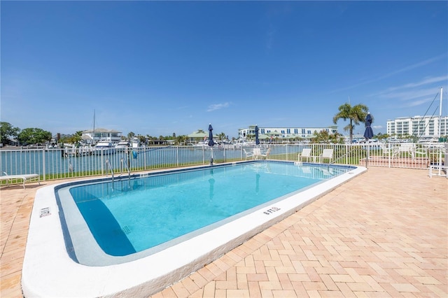 view of swimming pool with a water view and a patio