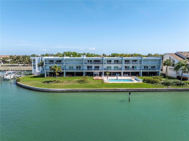 rear view of house with a yard and a water view