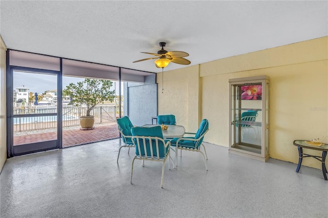 340 Pinellas Bayway S Unit 306, Tierra Verde, FL 33715 - dining space featuring a ceiling fan, speckle patterned floor, a wall of windows, and a textured ceiling