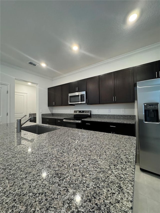 kitchen with light stone countertops, crown molding, stainless steel appliances, and sink