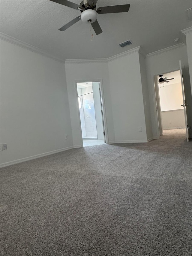 carpeted spare room featuring crown molding, ceiling fan, and a textured ceiling