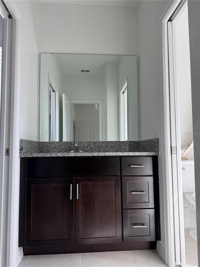 bathroom featuring tile patterned floors, vanity, and toilet