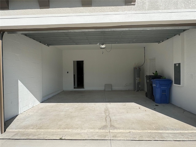 garage featuring a garage door opener, a carport, and water heater