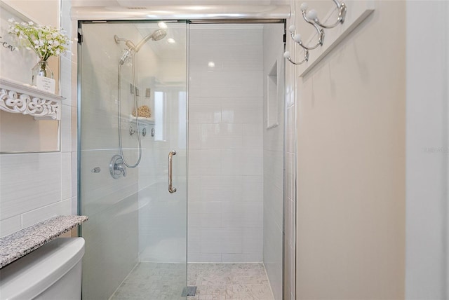 bathroom featuring toilet and an enclosed shower