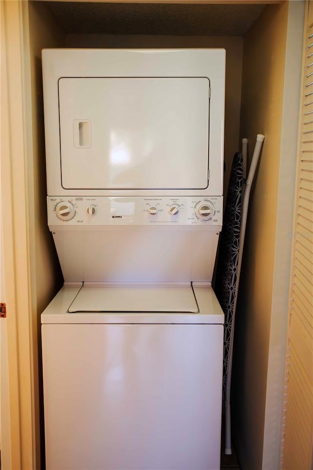 washroom featuring stacked washing maching and dryer