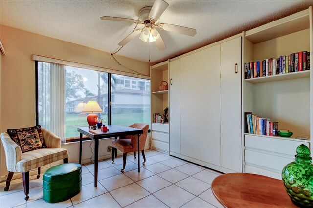 home office featuring light tile patterned floors, a textured ceiling, and a ceiling fan