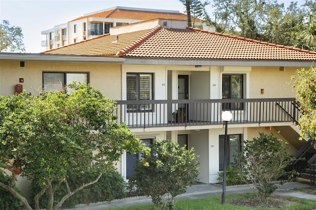 exterior space featuring a tile roof and stucco siding