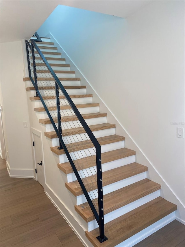 stairs featuring hardwood / wood-style floors