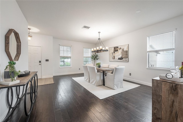 dining room with plenty of natural light, dark wood-type flooring, and a chandelier