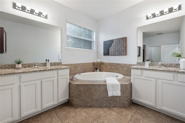 bathroom featuring tile patterned floors, vanity, and tiled tub