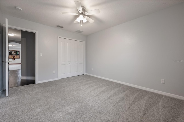 unfurnished bedroom featuring a closet, ceiling fan, and carpet