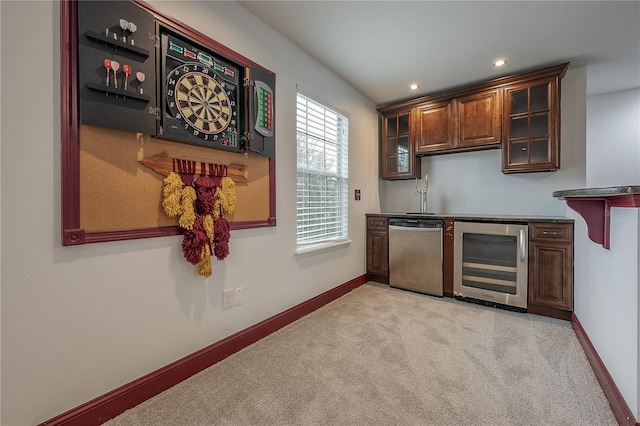 kitchen featuring light carpet, stainless steel dishwasher, and beverage cooler