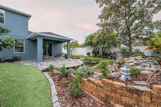 yard at dusk with a patio area