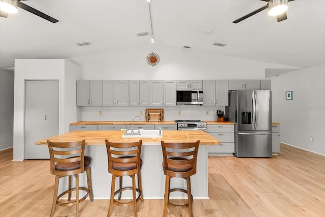 kitchen featuring ceiling fan, wood counters, gray cabinets, and stainless steel appliances