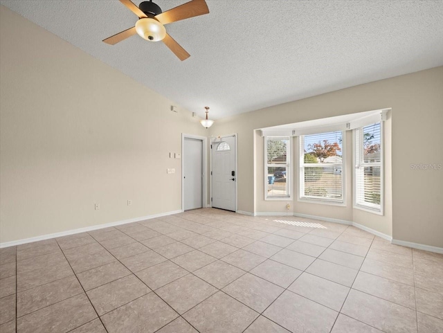 tiled spare room featuring a textured ceiling and ceiling fan