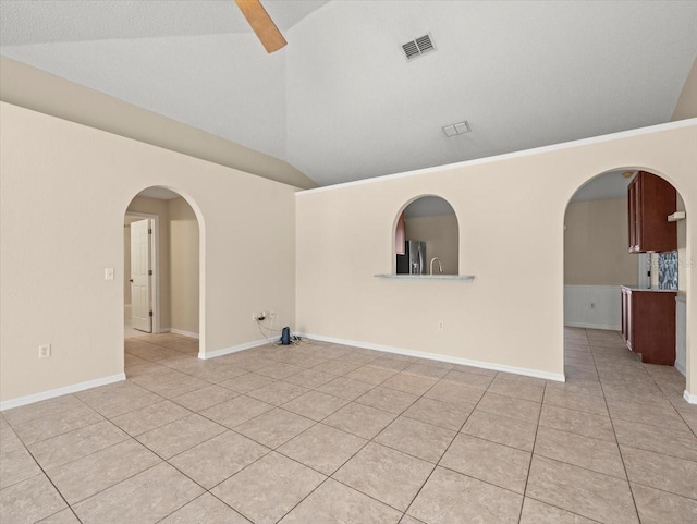 tiled empty room with crown molding and lofted ceiling