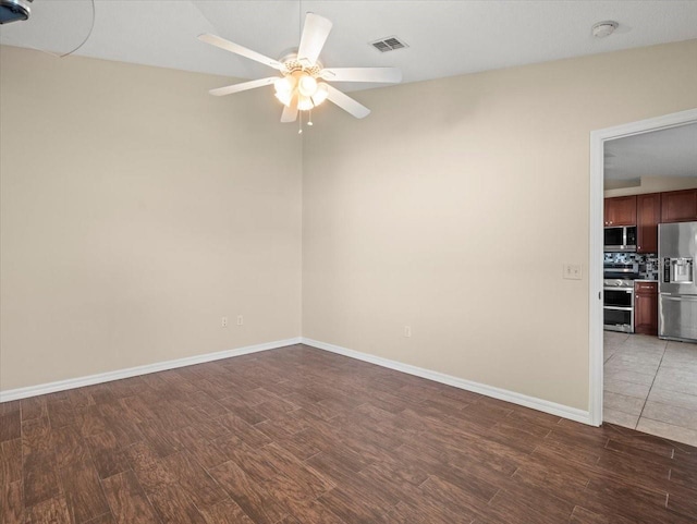 unfurnished room featuring ceiling fan, dark hardwood / wood-style floors, and vaulted ceiling