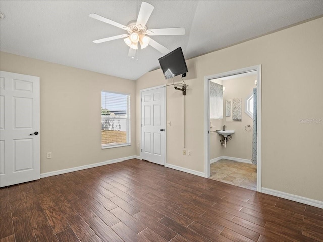 unfurnished bedroom with ceiling fan, ensuite bath, lofted ceiling, a textured ceiling, and sink