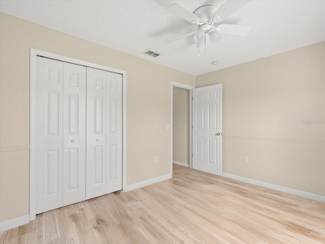 unfurnished bedroom with ceiling fan, a textured ceiling, a closet, and light hardwood / wood-style flooring