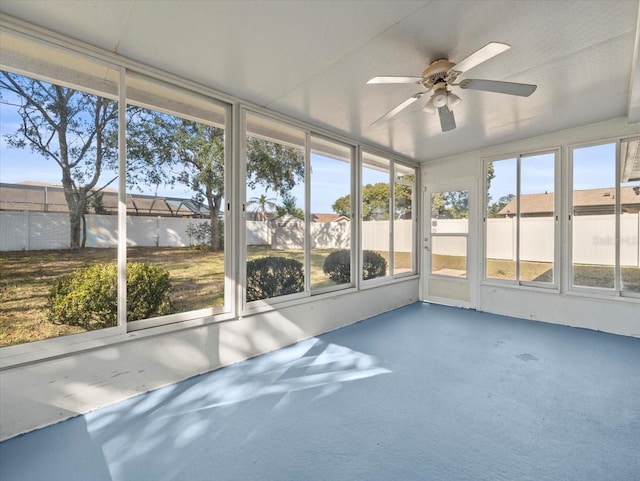 unfurnished sunroom with ceiling fan