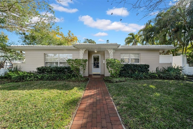 view of front of home with a front yard and fence