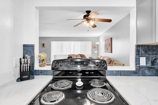 kitchen with light stone counters, ceiling fan, black electric range, and a textured ceiling