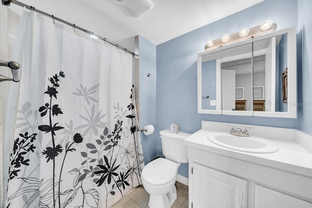 bathroom featuring tile patterned flooring, vanity, curtained shower, and toilet