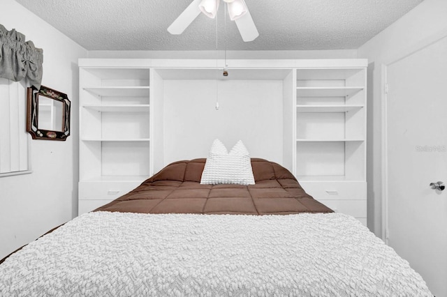 bedroom with ceiling fan and a textured ceiling