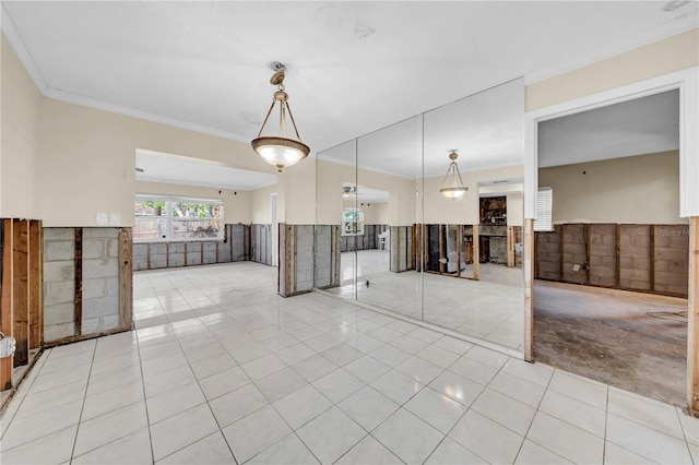 spare room with crown molding and light tile patterned flooring