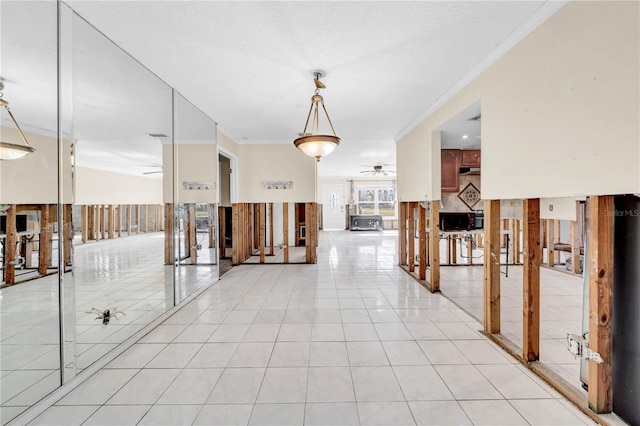 hallway featuring light tile patterned flooring, ornamental molding, and vaulted ceiling