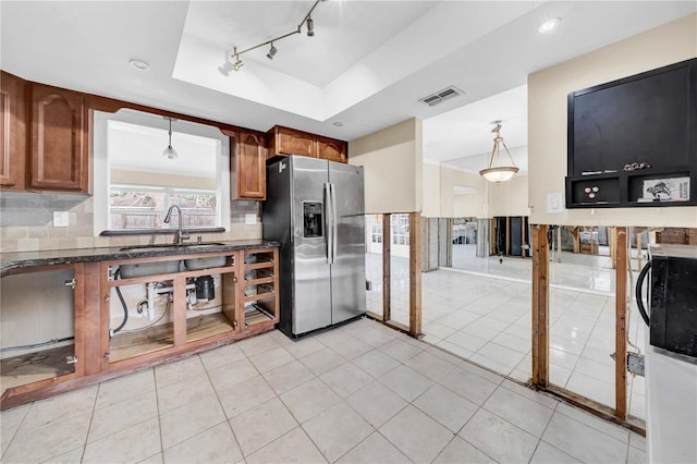 kitchen featuring sink, tasteful backsplash, stainless steel fridge with ice dispenser, a tray ceiling, and pendant lighting