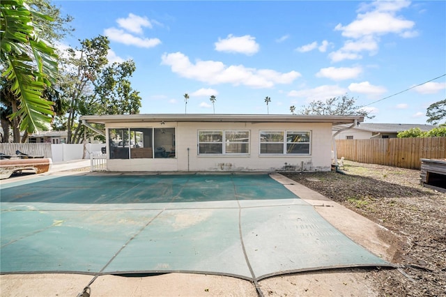 back of house with a covered pool