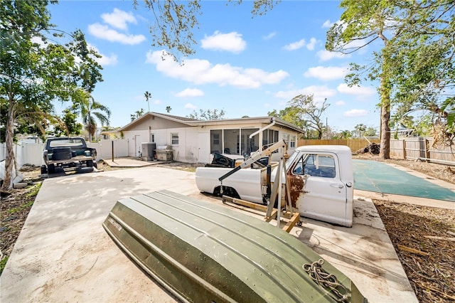 back of property featuring cooling unit, a sunroom, and a patio