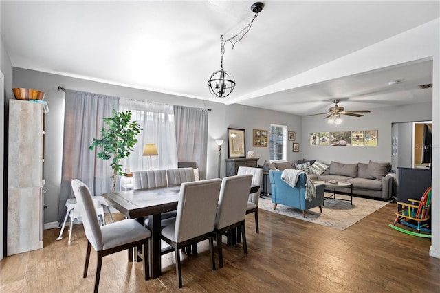 dining room with hardwood / wood-style flooring and ceiling fan with notable chandelier