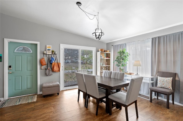 dining room featuring lofted ceiling, a notable chandelier, and dark hardwood / wood-style flooring