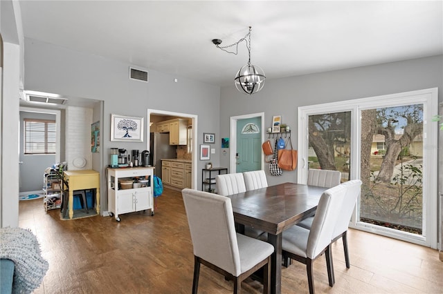 dining area featuring hardwood / wood-style floors and a notable chandelier